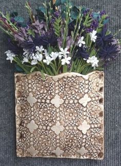 a vase with flowers in it sitting on the ground