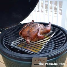 a chicken is being cooked on the grill with an open lid over it's side