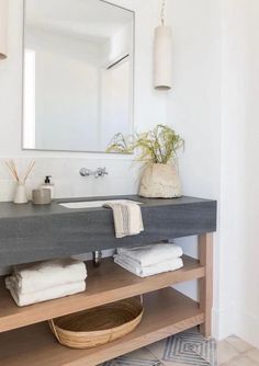 a bathroom with a sink, mirror and towel rack on the counter in front of it