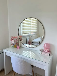 a white desk with a mirror, stool and other items on the table in front of it