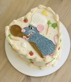 a cake decorated with an image of a mouse in a basket on top of a table