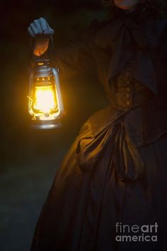 a woman holding a lantern in her hand