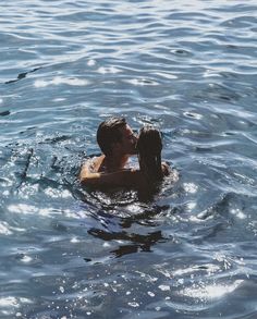 a man and woman kissing in the water