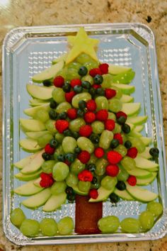 a christmas tree made out of grapes, apples and kiwis on a tray