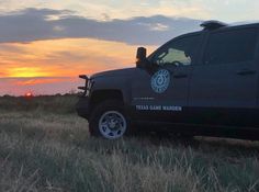 the truck is parked in the field at sunset