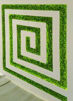 a wall with green grass covering it and white trimmings on the bottom half