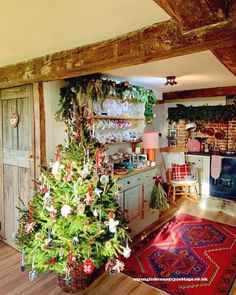 a decorated christmas tree in a rustic kitchen