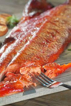 the fish is being prepared and ready to be eaten with a fork on the cutting board