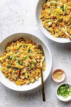 two bowls filled with rice and vegetables next to some dipping sauces on the side