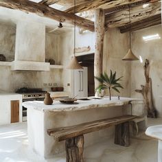 a rustic kitchen with white walls and wooden beams on the ceiling, along with an island bench