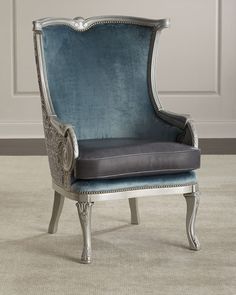 a blue chair sitting on top of a carpeted floor next to a white wall