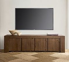 a flat screen tv sitting on top of a wooden cabinet