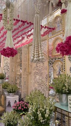 a room filled with lots of flowers and chandeliers hanging from the ceiling above