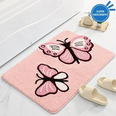 a pink bathroom rug with two butterflies on it