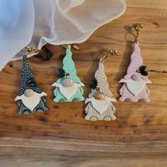 four christmas ornaments are sitting on a wooden table