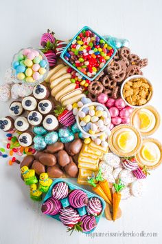 a table topped with lots of different types of candies and cookies on top of each other