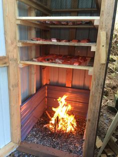 an open fire pit with lots of food on the top shelf and shelves above it