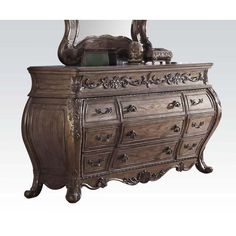 an ornate wooden dresser with mirror on top