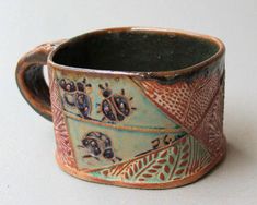 a close up of a cup on a white surface with an animal design in the middle