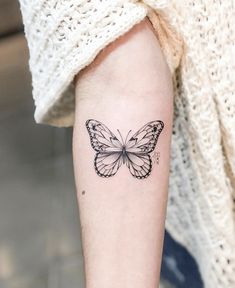 a woman's arm with a butterfly tattoo on the left side of her arm