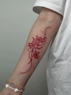 a woman's arm with red ink on the left side of her arm, and flowers