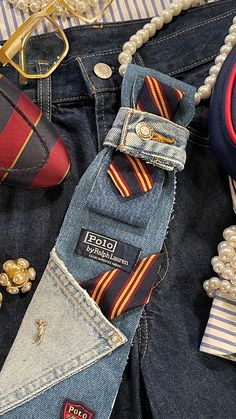 a pair of jeans with ties on them and other accessories next to each other,