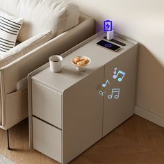 a table with a cell phone on it next to a couch and a coffee cup