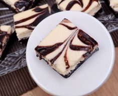 several pieces of cake on a plate with chocolate swirl toppings and one slice cut in half