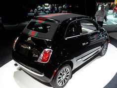 a small black car on display at an auto show