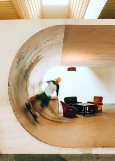 a man riding a skateboard up the side of a ramp in a concrete building