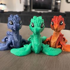 three different colored toys sitting on top of a table