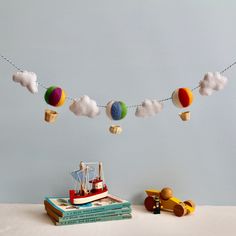 there is a toy boat and some books on the table with clouds in the sky