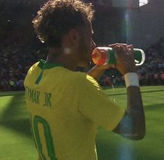 a soccer player drinking from a water bottle