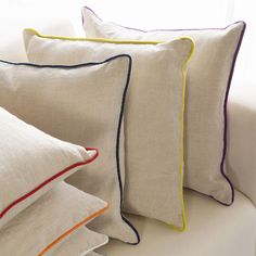 four pillows sitting on top of a white couch