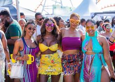 three beautiful women standing next to each other in front of a crowd at an outdoor event