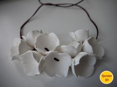 white flowers are on a string attached to a necklace