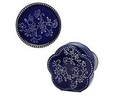 two blue plates with designs on them sitting next to each other in front of a white background