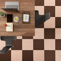 an overhead view of a table with laptops and other items on it, in the middle of a checkered floor