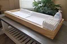 a baby crib with cleaning products on it and a potted plant in the background