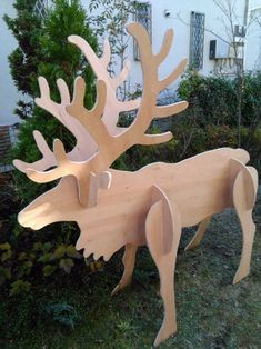 two wooden deer sculptures sitting in the grass