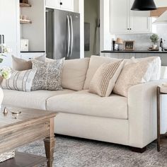 a living room filled with furniture next to a kitchen