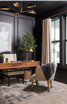 an office with black walls, gold accents and a wooden desk in front of a large window