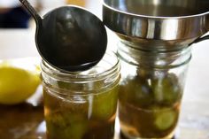 a jar filled with pickles next to a spoon