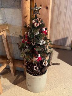 a small christmas tree in a pot on the floor