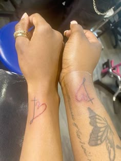 two people with tattoos on their arms and one is holding the other's hand