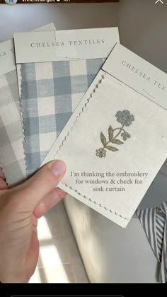 someone is holding up some fabric samples to show them on their cell phone screen, with the words chelsea textiles printed on it