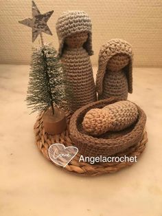 two crocheted animals sitting on top of a basket next to a small christmas tree