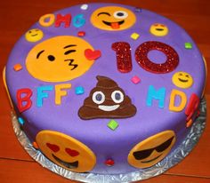 a purple cake with emoticions and faces on it sitting on top of a wooden table