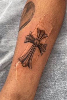 a man with a cross tattoo on his arm