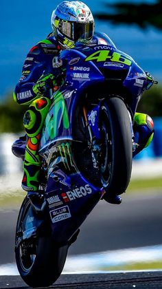 a man riding on the back of a blue motorcycle